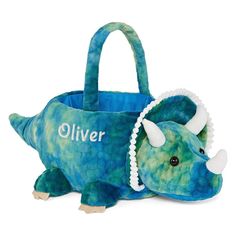 a blue stuffed animal laying on top of a white floor next to a bag with handles