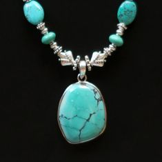 This stunning necklace has a large natural-turquoise pendant that was handcrafted in Nepal. MEASUREMENTS (1 inch = 2.54 cm): Pendant Size = 1-1/2 inches long x 1-1/8 inches wide x 1/4 inch deep Necklace Length = 21 inches Weight = 1.74 oz Shipping weight = 8 oz TM Image Library 6-3-2019 The large stone has the characteristic natural-turquoise veining and color. Sterling silver beads, turquoise, and silver-plated links extend up the sides, complementing the large pendant. It has a sterling-silver Contemporary Necklace, Handcrafted Necklace, Stunning Necklace, Agate Pendant, Turquoise Pendant, Natural Turquoise, Sterling Silver Bead, Necklace Length, Silver Beads