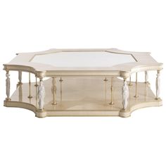 a white and gold coffee table with glass top