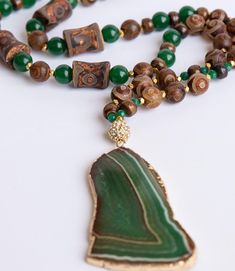 Tibetan agate, green agate, gold hematite and brass chain with large green agate slab. Bohemian style necklace is approximately 32". Looks great with the Freeform Green Recycled Brass Cuff, which is sold separately. Every item sold plants a tree through our partnership with One Tree Planted. Luxury Gold Agate Necklace, Luxury Statement Agate Jewelry, Pave Necklace, Brass Cuff, Horn Necklace, Horn Pendant, Dragon Jewelry, Pave Pendant, African Jewelry