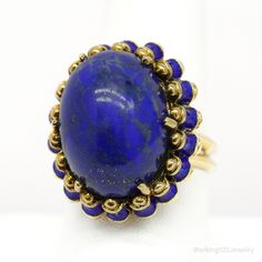 One (1) 14K yellow gold ring is centered with one (1) prong set, lapis lazuli described above. The ring is accented with blue enamel details and measures 25.3mm at the top, rises 15.2mm above the finger, tapering to 3.2 mm wide & 1.2mm thick at the base of the shank. Signed Martine. The ring weighs 16.68 grams. Appraised Value: $3,200.00 Independent Appraisal Included. Pictured boxes are not included. Shipping- Items will arrive carefully packed in a jewelry gift box, wrapped in bubble wrap, and Yellow Gold Lapis Lazuli Cabochon Jewelry, Classic Blue Enamel Jewelry, Elegant Blue Oval Enamel Ring, Blue Oval Enamel Rings, Blue Enamel Ring In 14k Gold, Round Shape, Blue Enamel Ring In 14k Gold, Blue Cabochon Sapphire Ring In 14k Gold, Blue 14k Gold Oval Cabochon Jewelry, Blue 14k Gold Enamel Ring For Formal Events