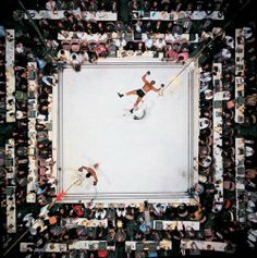 an aerial view of two men playing tennis in the middle of a room full of people