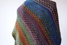 a colorful knitted shawl draped over a mannequin's dummy head