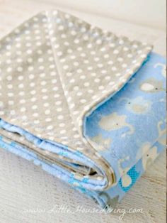 a blue and white polka dot blanket folded on top of a wooden table next to scissors