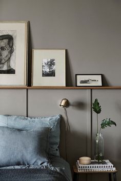 a bedroom with gray walls and pictures on the wall