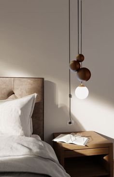 a bed with two lamps hanging from it's headboard next to a night stand