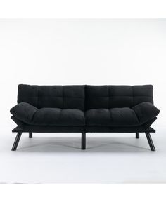 a black couch sitting on top of a white floor