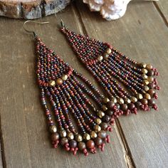 Native earrings Tribal boho brick stitch dangle earrings brown red handmade earrings agueva stone earrings fan jewelry earrings for women Brick stitch beaded earrings in 11/0 seed beads of a brown, dark red, bronze mix of Czech beads, so perfect for summer dresses. I added in some 3mm Czech crystals In bronze and 5mm aqueva Nuevo stone beads, and of course with my original design across top, bronze ear wires. Handmade beaded on durable fire line. Length: 3 inches Brick stitch is an old and rever Bohemian Beaded Dangling Earrings, Bohemian Beaded Dangle Earrings, Bohemian Brown Earrings As Gift, Bohemian Brown Earrings For Gift, Handmade Bohemian Brown Earrings, Handmade Brown Bohemian Earrings, Beaded Bohemian Chandelier Earrings, Handmade Artisan Dangle Chandelier Earrings, Brown Bohemian Dangle Jewelry