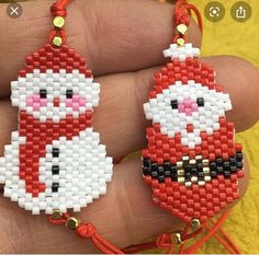 two red and white beaded christmas ornaments on a person's hand