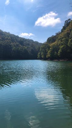 the water is very calm and clear for us to see in the distance, with trees on both sides