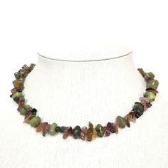 Gorgeous jewel tones come together in this textured collar necklace in watermelon tourmaline and green serpentine jade. Handcrafted from watermelon tourmaline chips, faceted tourmaline, and serpentine jade, this is a sophisticated and unique statement necklace. Approximately 16" long BrassTourmalineSerpentine Jade Green Tourmaline Gemstone Necklace, Green Tourmaline Jewelry With Natural Stones, Handmade Green Tourmaline Necklaces, Unique Statement Necklace, Watermelon Tourmaline, Jewel Tones, Come Together, Collar Necklace, Tourmaline