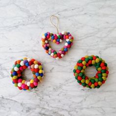 three pieces of colorful beaded jewelry sitting on a marble counter top next to each other