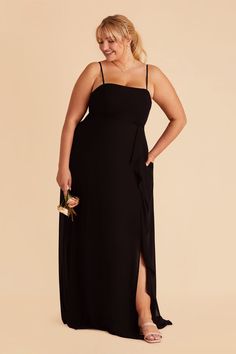 a woman in a black dress with her hands on her hips