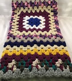 a crocheted blanket with an eye on the center is laying on a bed