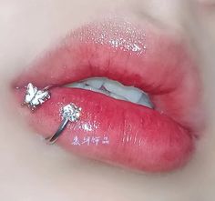 a woman's lips are covered in glitter and has a ring on her lip