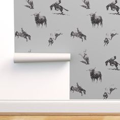 a wallpaper with horses on it and a roll of paper in front of it