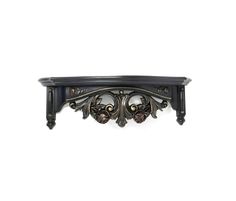 an ornate black shelf with two skulls on it