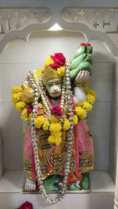 the statue is decorated with flowers and garlands