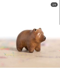 a brown bear figurine sitting on top of a table