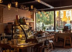 a restaurant with lots of tables and chairs in front of large windows that look out onto the street