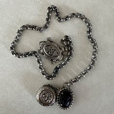 Excellent antique condition! Such a unique piece, dates to around the early Victorian Romantic period of 1840. Possibly a mourning guard chain or chatelaine belt as the cameo is carved from what is either jet, onyx, or a combination of both. Each end ornament has a set of two hook teeth to be affixed to the wearer's shoulders or waist. Unsure of full metal content, piece is non-magnetic except for two small components used in the swivel function of the hooks. Based on the time period, it is likely a silver alloy. Features hammered repousse charms including the black cameo, coat of arms, and a round seal of some sort. Measurements: Chain length 16.5 in / 42 cm Shield length 1.38 in / 4 cm Size: Womens OS Condition: Pre-Owned  Tags: true antique Silver Cameo Metal Necklace, Silver Metal Cameo Jewelry, Silver Metal Cameo Necklace, Victorian Metal Medallion Jewelry, Victorian Style Metal Medallion Jewelry, Antique Cameo Metal Jewelry, Antique Metal Cameo Jewelry, Victorian Cameo Metal Jewelry, Victorian Jewelry With Oxidized Finish, Collectible