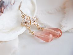 "These beautiful art deco earrings are created with wire wrapped pink glass teardrops and accented with tiny cubic zirconia fans. These are secured to dainty 14k gold filled earring wires for a comfortable all day wear. These simple yet elegant pink wedding earrings are the perfect beach wedding, rustic wedding accessory for your bridesmaids and compliment many boho bridal attire adding a dose of subtle glam to your wedding day. Your boho bridal earrings will arrive suitably gift wrapped ready f Handmade Pink Crystal Earrings For Wedding, Delicate Pink Party Earrings, Wedding Crystal Dangle Earrings Wire Wrapped, Wedding Crystal Drop Earrings Wire Wrapped, Wire Wrapped Crystal Dangle Earrings For Wedding, Wire Wrapped Crystal Drop Earrings For Wedding, Wedding Wire Wrapped Crystal Drop Earrings, Elegant Peach Earrings For Wedding, Elegant Peach Wedding Earrings