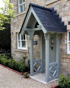 a small gray building with a black roof