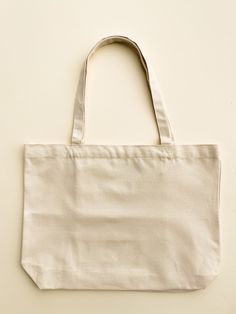 "Our Minimalist Wide Tote makes for the summer beach bag. To increase the functionality, we added interior pockets so you can keep your small items right where you want them.  -Can hold up to 34 lbs -Hand painted in the US -Interior pockets, magnet closure -Size: 18\" width by 13\" height -Strap length: 23" Minimalist Beige Bag For On-the-go, Eco-friendly On-the-go Bags With Pockets, Reusable Rectangular Bag For On-the-go, Practical Beige Tote Bag, Practical Everyday Bag, Minimalist Rectangular Canvas Bag For Everyday Use, Cream Minimalist Bag For Everyday, Minimalist Beige Bags For Everyday Use, Minimalist Canvas Shoulder Bag For Travel