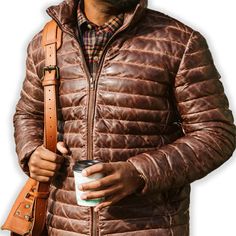 Rugged style meets winter warmth in our Men's Brown Leather Puffer Jacket. Crafted from supple, genuine leather with a rich brown hue, this jacket features quilted puffer insulation for superior heat retention. The classic silhouette is enhanced with a stand-up collar, zippered front, and snug cuffs to keep the cold at bay. Practical side pockets provide storage and hand-warming comfort. Perfect for the fashion-conscious man who doesn't compromise on functionality, this jacket seamlessly transitions from outdoor adventures to city streets. Key features: Premium brown sheepskin leather exterior for durability and style Quilted puffer design for superior insulation Adjustable hem to seal out cold air Multiple pockets for convenient storage Satin lining for a luxurious feel Premium YKK zipper Biker Shirts Women, Spiked Leather Jacket, Mens Leather Blazer, Motorcycle Leather Vest, Racer Jackets, Thigh Bag, Western Bag, Varsity Jacket Women, Leather Puffer Jacket