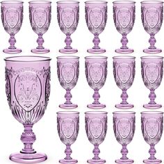 a set of twelve purple glass goblets sitting next to each other on a white background