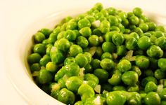 green peas in a white bowl on a table