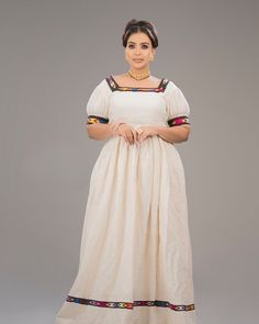 This elegant dress blends tradition with modern flair, making it a standout piece for cultural and formal events. It is adorned with narrow handmade Tilef around the neckline, sleeves and hemline, giving it a sophisticated traditional look. Material Cotton Thread Estimated delivery : 1week to 2weeks Contact WhatsApp +1(304)-306-2784Email: contact@ethiopian.store Traditional Floor-length Dresses With Embroidered Border, Traditional Short Sleeve Dresses For Ceremonies, Traditional Dresses With Short Sleeves For Ceremonies, Traditional Long Embroidered Dress, Traditional Long Dress With Resham Embroidery, Traditional Short Sleeve Dresses For Navratri, Multicolor Embroidered Fitted Maxi Dress, Navratri Embroidered Straight Kurta Dress, Floor-length Anarkali Dress With Embroidered Border