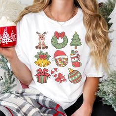 Get into the festive spirit with our Christmas T-shirt, adorned with an array of adorable holiday-themed graphics. This shirt perfectly captures the essence of the holiday season, making it the ideal choice for anyone looking to spread some cheerful vibes. The playful and vibrant designs will bring joy to your celebrations, whether you're attending a Christmas party, gathering with family, or just enjoying the season in style. WHY YOU'LL LOVE THIS SHIRT: Festive Fun: The charming graphics on thi New Year Holiday Crew Neck T-shirt, New Year Gift Crew Neck T-shirt, Holiday White T-shirt With Graphic Print, Holiday White Graphic Tee, Holiday White Graphic Tee Top, White Graphic Tee For Holiday, White Holiday Graphic Tee, Graphic Print Tops For New Year Holiday, Christmas Graphic Tee As Gift