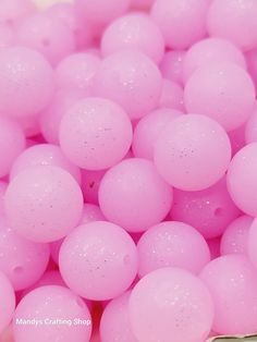 many pink balls are in a bowl on the table and it looks like they have been filled with water