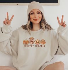 Embrace the rustic charm of autumn with our "Country Pumpkins" sweatshirt. This cozy and stylish sweater features a delightful row of four western pumpkins, capturing the essence of a serene countryside pumpkin patch. Crafted with care, this sweatshirt brings together comfort and seasonal aesthetics, making it a perfect addition to your fall wardrobe. Made from premium quality materials, our sweatshirt ensures warmth and durability, while its unique design adds a touch of autumnal magic to any o Soft-washed Sweater For Fall, Soft-washed Fall Sweater, Cozy Soft-washed Sweater For Fall, Cute Long Sleeve Fall Sweatshirt, Cute Long Sleeve Sweatshirt For Fall, Cute Relaxed Fit Sweatshirt For Fall, Cute Cozy Fit Tops For Fall, Cute Oversized Hoodie For Fall, Cute Fall Loungewear Sweatshirt