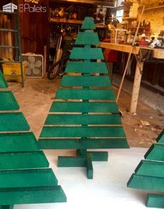 three green wooden christmas trees sitting on top of a table