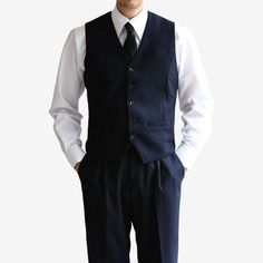 Introducing the Classic Fit Men's Basic Wool Blend Suit Vest in Navy Color. This dress suit waistcoat is a stylish addition to elevate any gentleman's formal attire. Designed with a classic fit, this vest offers a timeless and sophisticated silhouette. The navy color adds a touch of refinement, making it suitable for a variety of formal occasions and events. The 5-button design of this waistcoat adds a polished and traditional touch. It features a clean and minimalistic design, allowing it to effortlessly complement any dress shirt and suit combination. Whether you're attending a wedding, a business meeting, or any formal event, the Classic Fit Men's Basic Wool Blend Suit Vest in Navy Color is the perfect choice to complete your formal ensemble. It exudes sophistication and adds a refined Notch Lapel Vest With Buttons For Business Casual, Business Casual Vest With Notch Lapel And Buttons, Sleeveless Suits With Buttons For Work, Sleeveless Business Outerwear With Button Closure, Formal Notch Lapel Vest With Buttons, Notch Lapel Three-piece Suit With Buttons For Work, Notch Lapel Three-piece Suit For Work, Workwear Three-piece Suit With Notch Lapel And Buttons, Tailored Semi-formal Vest With Button Closure