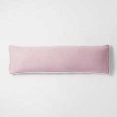 a pink pillow on a white wall with a light pink border around the edge,