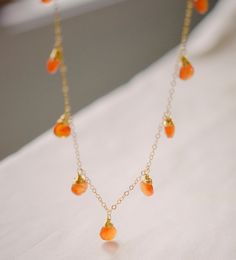 "Embrace the magic of Carnelian with our natural multi-teardrop necklace! Handcrafted with authentic Carnelian gems, this necklace is perfect for that classic look. And for those who love a boho-chic style...it plays well with others and loves to be layered! Carnelian, an orange variety of Quartz, is said to act as an energy booster, stimulating your motivation, endurance, and courage. So go ahead, let this dainty piece turn heads and hearten your spirits! This piece will be hand-made for you in your choice of sterling silver or 14k gold filled. Stones will vary slightly in color, with some containing reddish banding, while others will be solid orange or orange-red.  GEMSTONE: Natural Carnelian STONE SIZE: Average 7 to 10mm (.27\" to .4\")  STONE SHAPE: Faceted Heart Briolette METAL: 14k G Orange Crystal Necklace, Orange Briolette Jewelry For Gift, Orange Gemstone Drop Jewelry, Orange Drop Gemstone Jewelry, Handmade Orange Teardrop Necklace, Carnelian Gemstone Drop Jewelry, Amber Drop Gemstone Necklace, Orange Drop Jewelry For Gift, Gold Carnelian Teardrop Jewelry