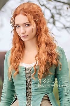 a woman with long red hair wearing a green dress