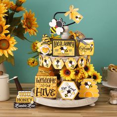 a cake with sunflowers and bees on it sitting on a table next to other decorations