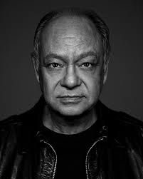 black and white photo of man in leather jacket looking at camera with serious look on face