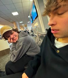 two young men sitting next to each other in an office building, one with his mouth open