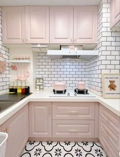 a kitchen with pink cabinets and white tile