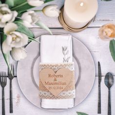 a place setting with flowers, candles and napkins on the table for guests to eat