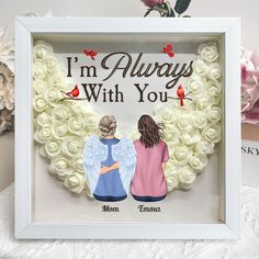 two people sitting in front of a heart shaped frame with roses on it and the words i'm always with you