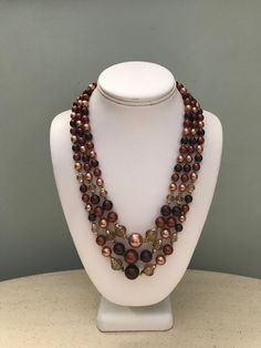 Brown Tones Pearl Bead Choker  Triple Strand Plastic Pearls  Translucent Faceted Beads  Chunky Graduated Beads  Adj. Clasp 23 inch Choker Marked Hong Kong - Vintage 1960s  Size: 20-23 inches adj. hook clasp Condition: Very fine, no nacre loss on pearls, lightweight More Bead Necklaces: http://etsy.me/1J0tDch Costume Jewelry Beaded Necklaces For Jewelry Making, Costume Jewelry Spacer Beads For Jewelry Making, Brown Beaded Necklaces With Oval Beads, Round Faceted Beads Pearl Necklace For Jewelry Making, Costume Jewelry Pearl Necklace With Beaded Chain, Faceted Beads Pearl Necklace For Jewelry Making, Brown Beaded Necklace With Oval Beads, Brown Long Beaded Necklace With Faceted Beads, Costume Pearl Necklace With Round Beaded Chain