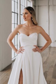 a woman in a white dress posing for the camera