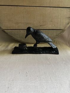 a black bird figurine sitting on top of a pillow