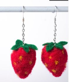 two red strawberries hanging from chains on a white background with text overlay that reads how to make needle felt strawberry earrings